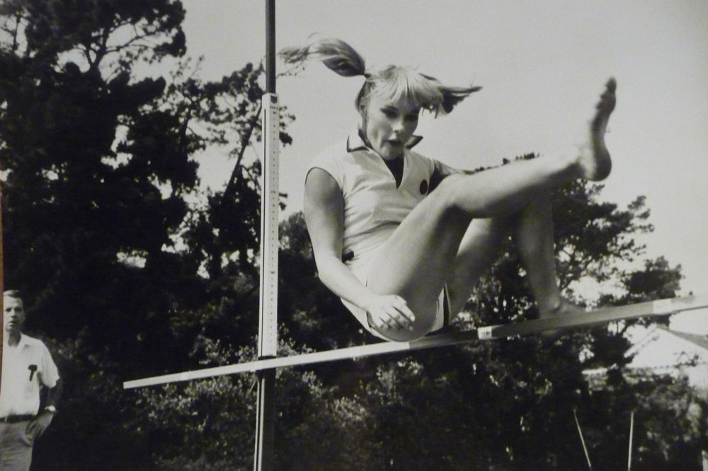 Elke Sommer Jumping Over Pole Photo Print showcasing dynamic motion.