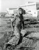 Elke Sommer sitting on rocks wearing patterned pants and bra photo print.