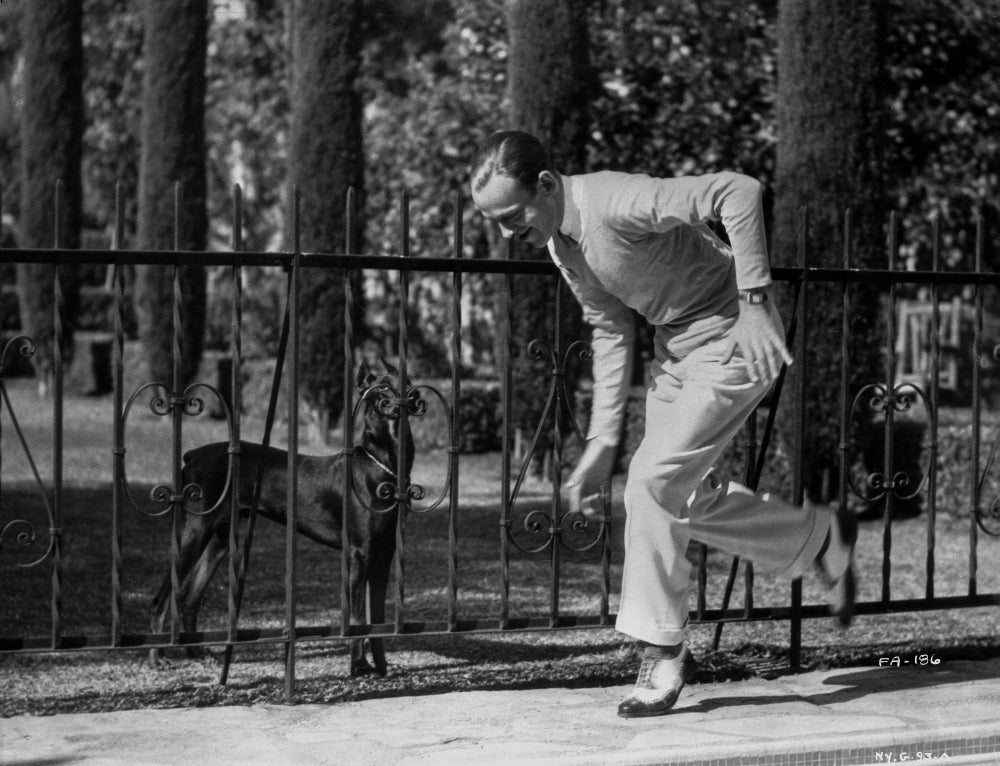 Fred Astaire playing with dog photo print, classic film memorabilia.