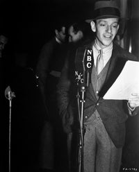 Black and white photo print of Fred Astaire reading in a suit.