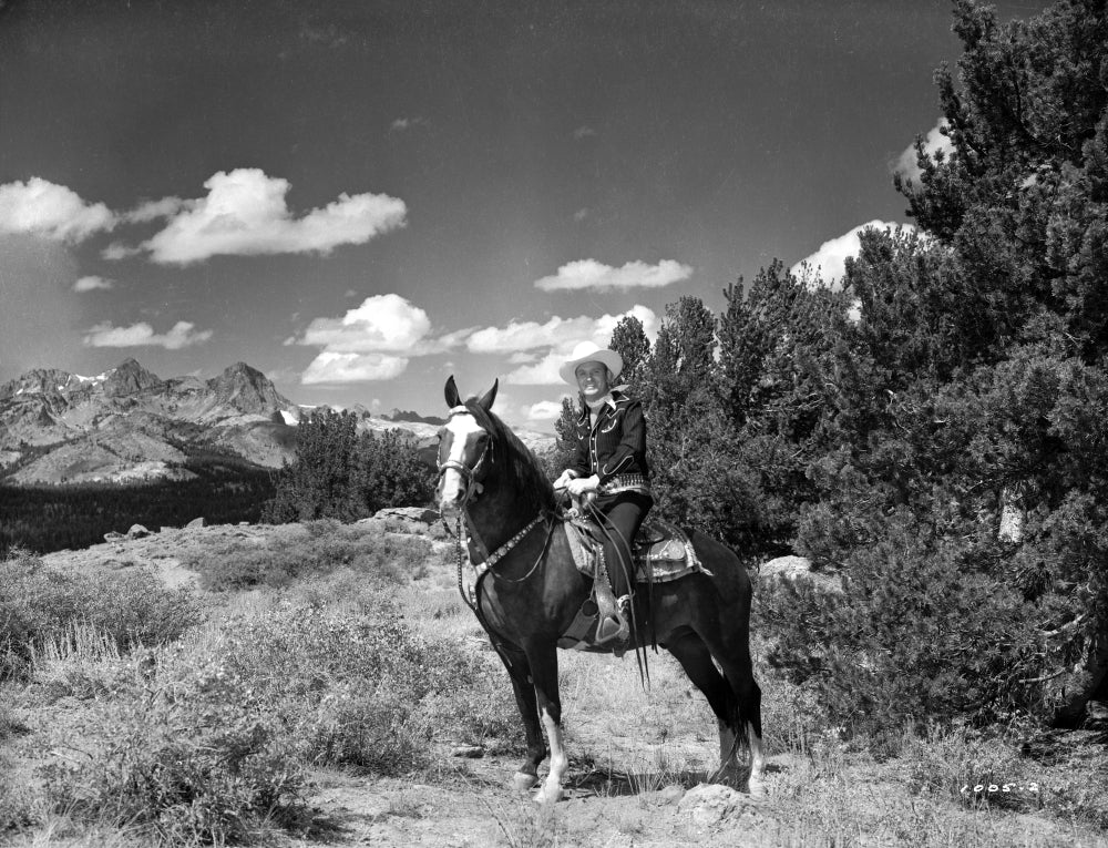 Gene Autry riding a horse in Western outfit photo print.