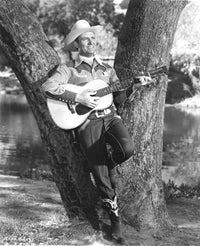 Gene Autry playing guitar against a tree photo print