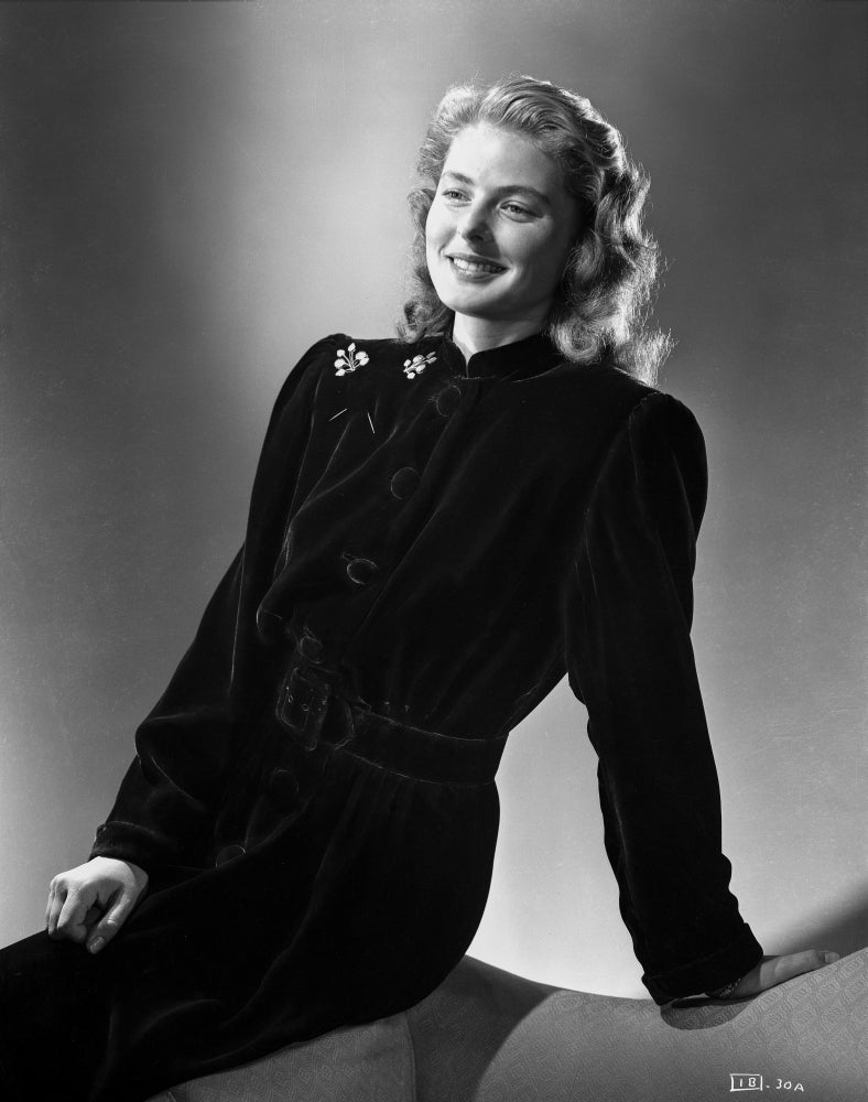 Ingrid Bergman sitting on a couch in a long sleeve dress with brooch photo print