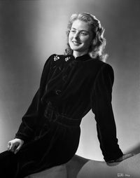 Ingrid Bergman sitting on a couch in a long sleeve dress with brooch photo print