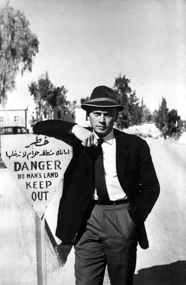 Yul Brynner leaning on a sign photo print showcasing classic cinema.