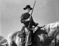 Tom Laughlin film still photo print of him riding a horse with a gun.
