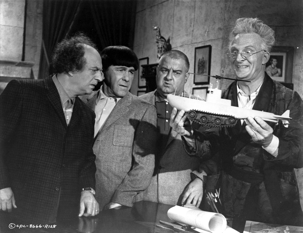 Film still of Emil Stika carrying a model ship photo print.