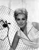 Kim Novak Leaning Photo Print showcasing classic Hollywood elegance.