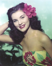 Close up portrait of Debra Paget wearing a floral dress, vintage photo print.