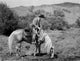 Roy Rogers riding on a horse eating grass photo print