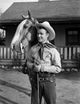 Roy Rogers photo print standing and holding horse's reins.