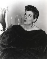 Jane Russell portrait in black fur coat and pearl earrings looking up