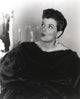 Jane Russell portrait in black fur coat and pearl earrings looking up