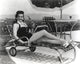 Jane Russell lying on a folding bed wearing a black dress, vintage photo print.