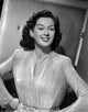 Rosalind Russell smiling with hands on hips photo print