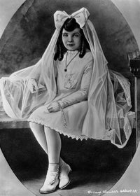 Claudette Colbert sitting on a bed in a white dress with veil photo print.
