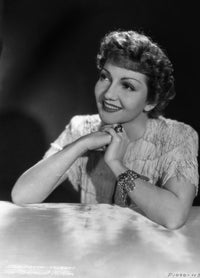 Claudette Colbert leaning on a table photo print with black background