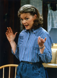 Photo print of Jane Curtin in blue linen long sleeve shirt with hands raised.