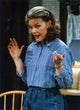 Photo print of Jane Curtin in blue linen long sleeve shirt with hands raised.