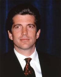 Close-up portrait photo print of John F. Kennedy in a black suit and glossy necktie.