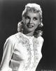 Janet Leigh in a white embroidered long sleeve cotton smock photo print on black background.
