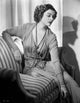 Myrna Loy posed on couch photo print showcasing classic Hollywood elegance.