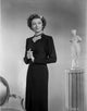 Myrna Loy standing in a long sleeve dress - vintage photo print