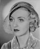 Bette Davis portrait photo print in round straw hat and polka dot necktie.