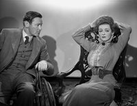 Bette Davis seated in a high neck long sleeve dress with hands on head photo print.