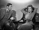 Bette Davis seated in a high neck long sleeve dress with hands on head photo print.