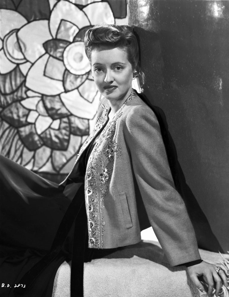 Bette Davis reclining on a white box in embroidered suit and black dress photo print