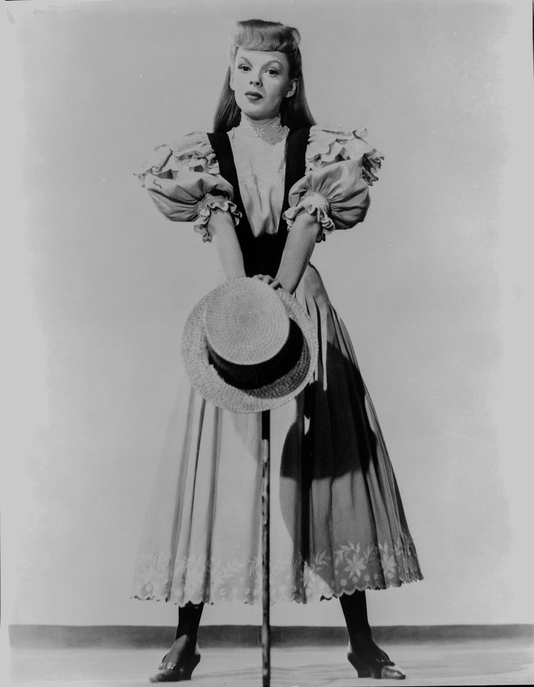 Judy Garland photo print in dress, cane, and hat, capturing classic Hollywood charm.