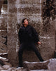 Benicio Del Toro leaning on wall in black coat photo print.
