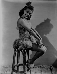 Betty Grable seated photo print showcasing vintage glamour in a strap dress with fur accents.