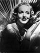 Photo print of Georgia Carroll smiling with red lipstick and curly hair.