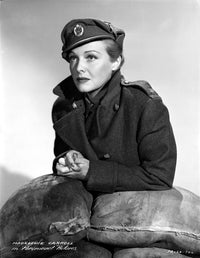 Madeleine Carroll leaning on sandbags in a black suit photo print.