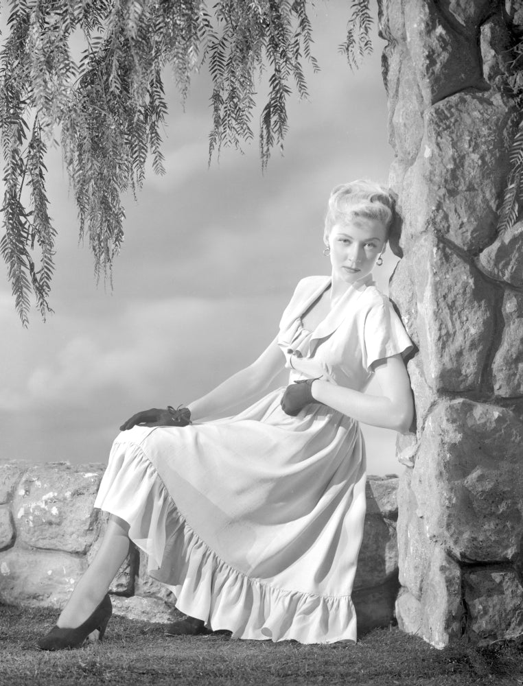 Gloria Grahame leaning on rock in a white dress photo print.
