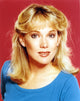 Close-up portrait photo print of Julia Duffy in blue tunic and earrings.