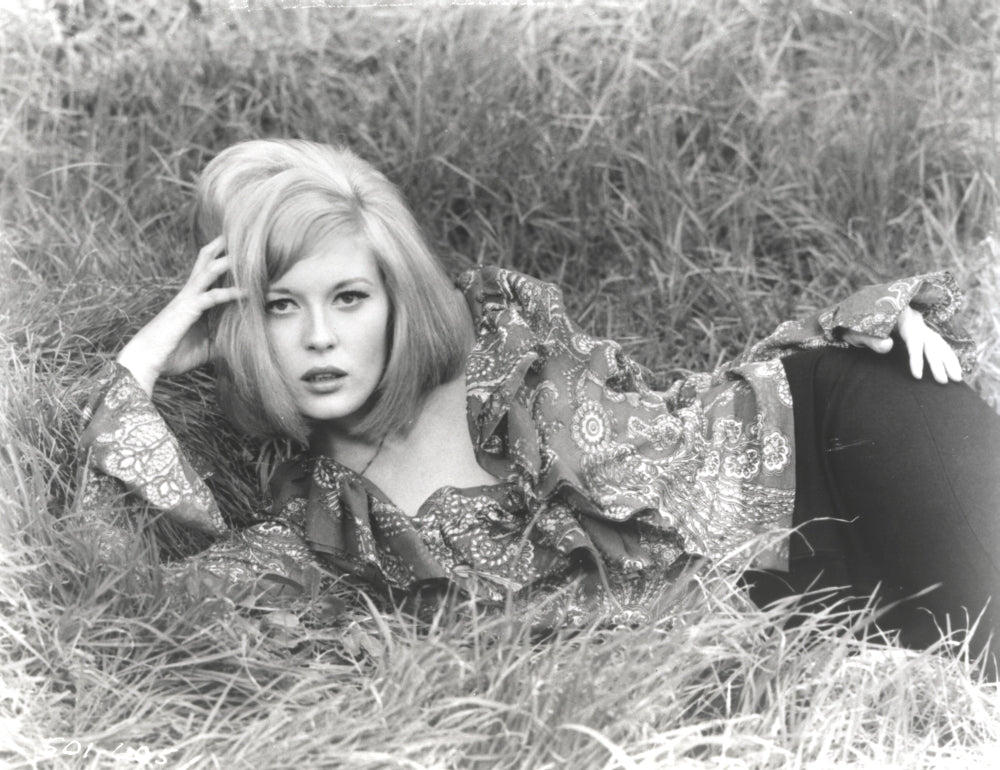Faye Dunaway lying in classic photo print showcasing elegance and charisma.