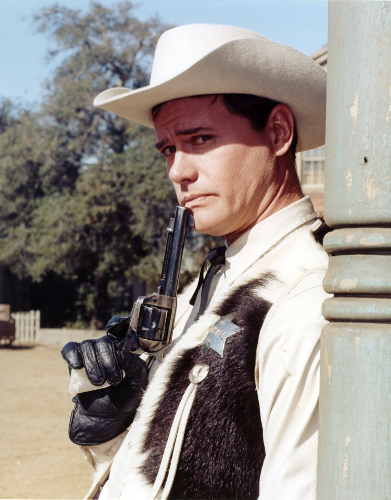 Larry Hagman smiling in sheriff uniform holding a pistol photo print