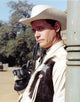 Larry Hagman smiling in sheriff uniform holding a pistol photo print