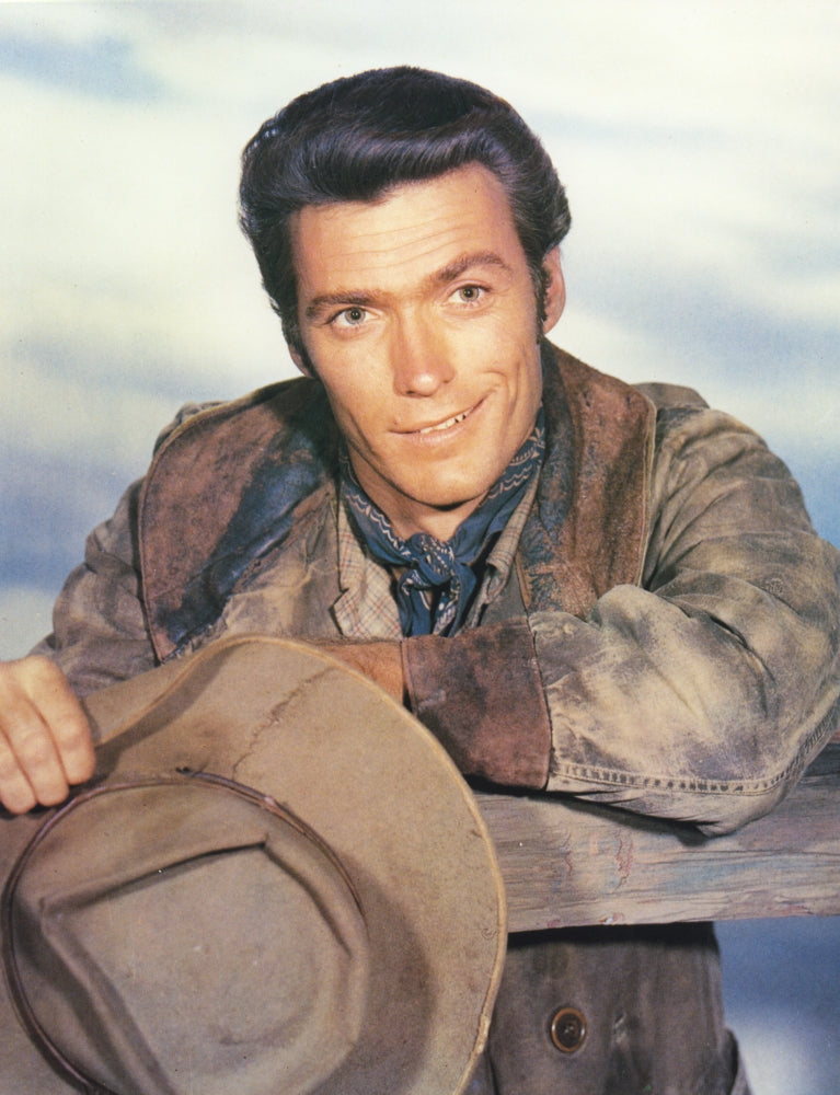 Clint Eastwood leaning on a fence wearing cowboy attire photo print