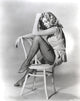 Anita Ekberg sitting on a chair in a classic portrait photo print.