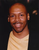 Close-up portrait photo print of Kevin Eubanks smiling.