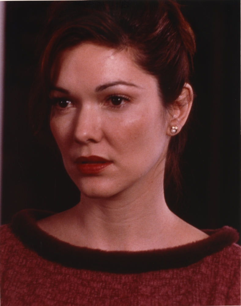 Close-up portrait photo print of Laura Harring in a red sweater with earrings.