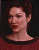 Close-up portrait photo print of Laura Harring in a red sweater with earrings.
