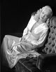 Myrna Dell sitting on couch in silk dress black and white photo print