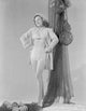 Susan Hayward smiling in trench coat and white bikini photo print.