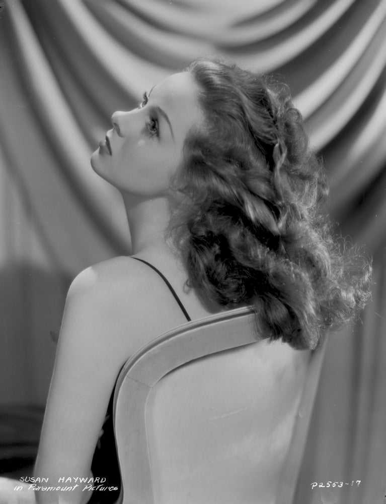 Susan Hayward sitting on a chair with curly hair photo print