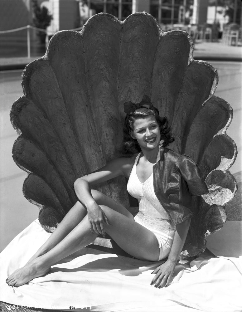 Rita Hayworth posed elegantly with a big shell photo print.